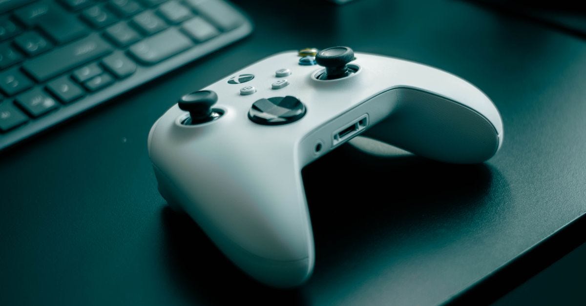 Close-up of a white game controller on a sleek desk, highlighting technology and gaming.