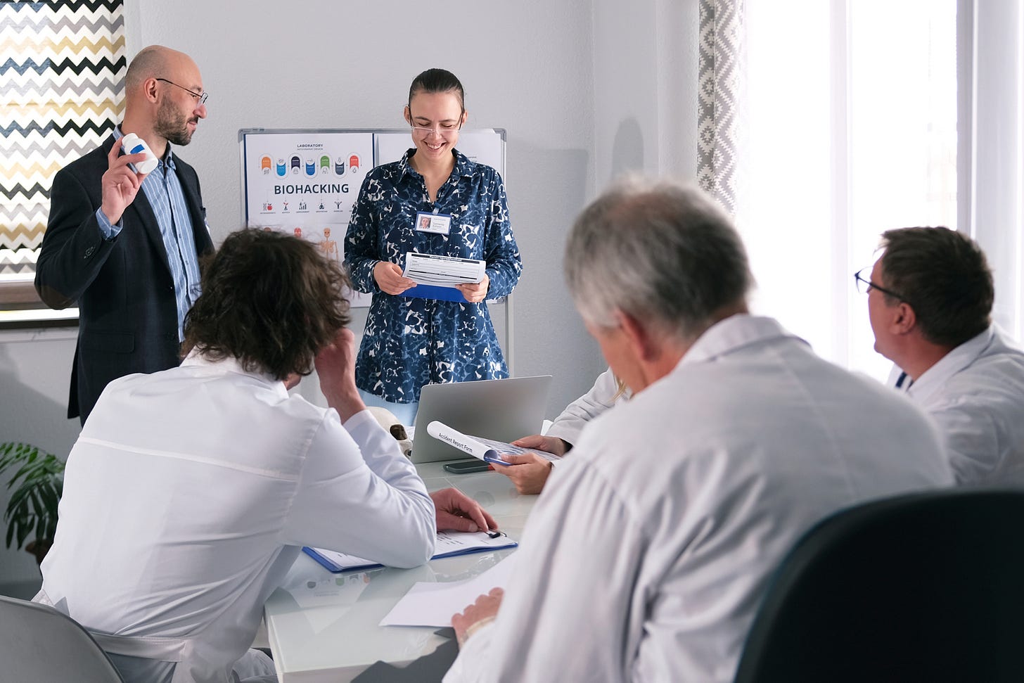 Team meeting with professionals in a modern office setting discussing data and strategy for biomedical innovation.