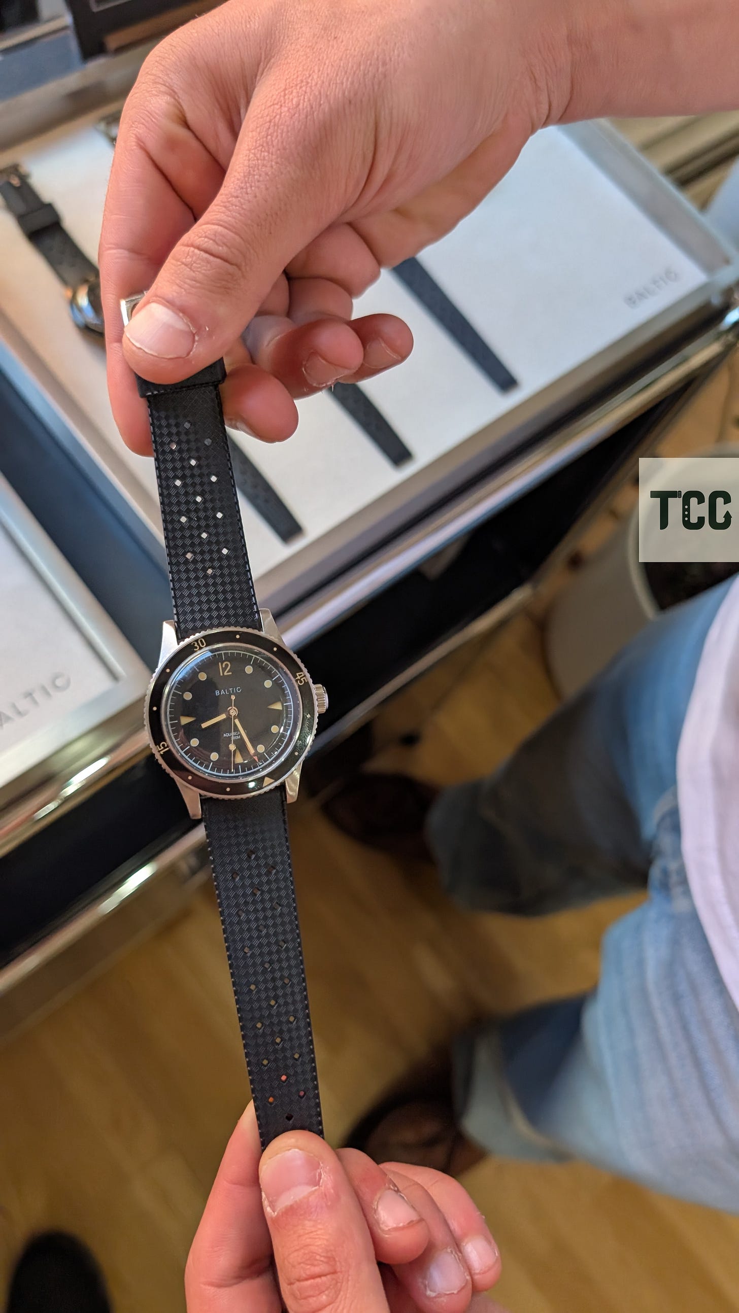 A man holds a watch by its straps.