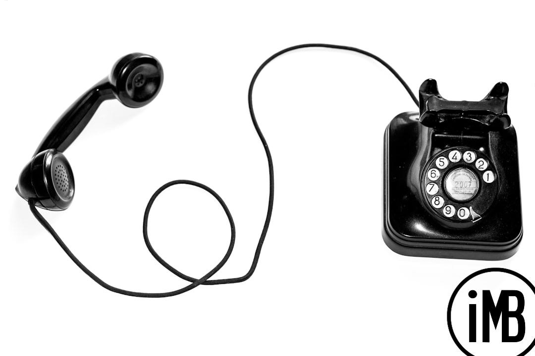 photo of black rotary phone against white background