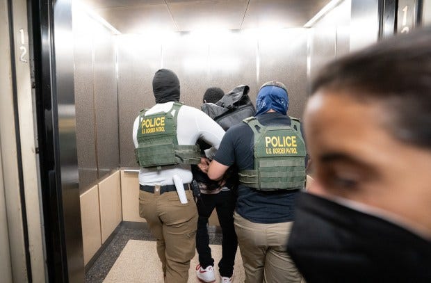 Federal law enforcement officers take an immigrant into custody in the Jacob K. Javits Federal Building.