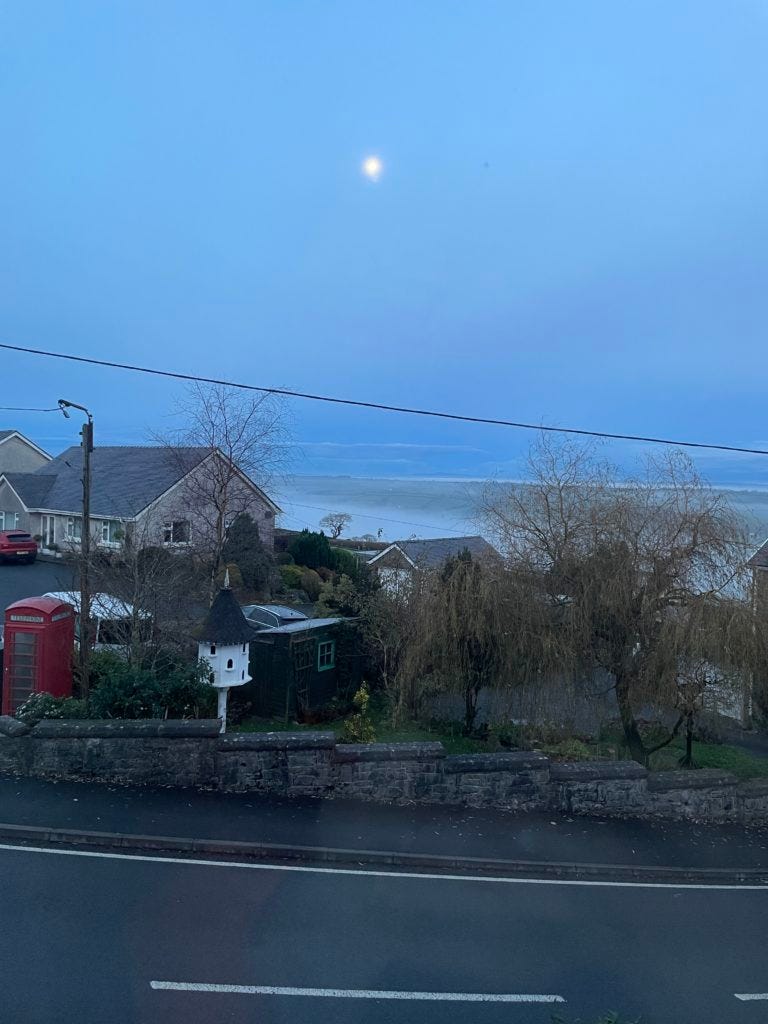 A full moon above a Welsh village covered in frost.