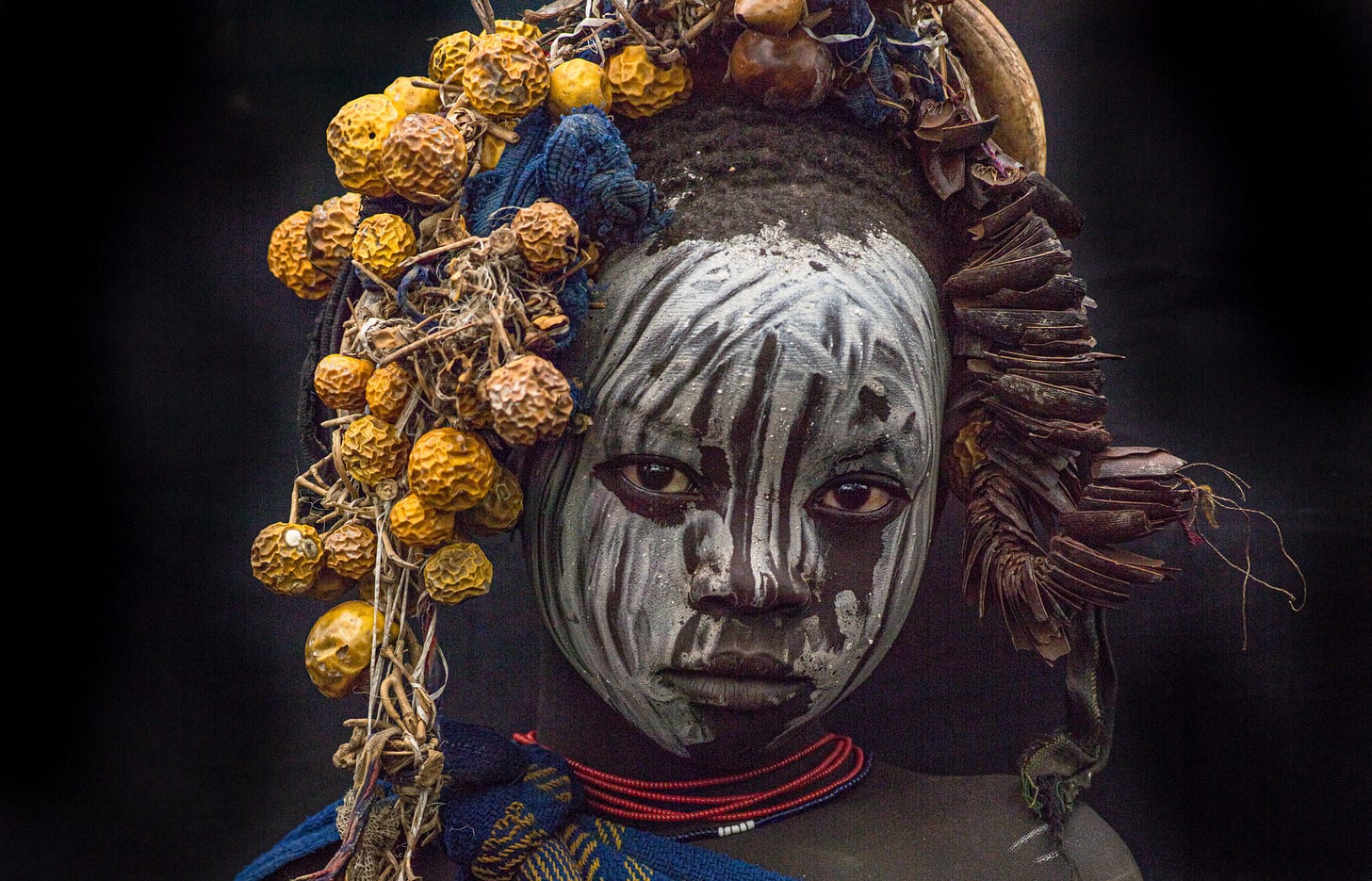 Foto von Farin Urlaub, bemaltes und geschmücktes Kind in Äthiopien blickt ernst in die Kamera Foto von Farin Urlaub, bemaltes und geschmücktes Kind in Äthiopien blickt ernst in die Kamera