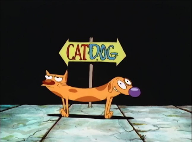 Cartoon image of a conjoined cat (facing left, with an unimpressed look on his face) and dog, facing right with an open expression. There's a sign behind them saying 'CATDOG', all as one word, and this is an image from a 1990's TV cartoon called CatDog.