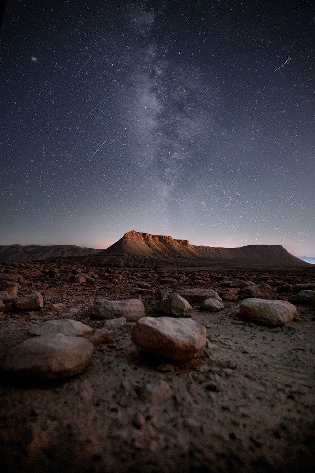 Rocky terrain at night against starry sky Rocky terrain at night against starry sky