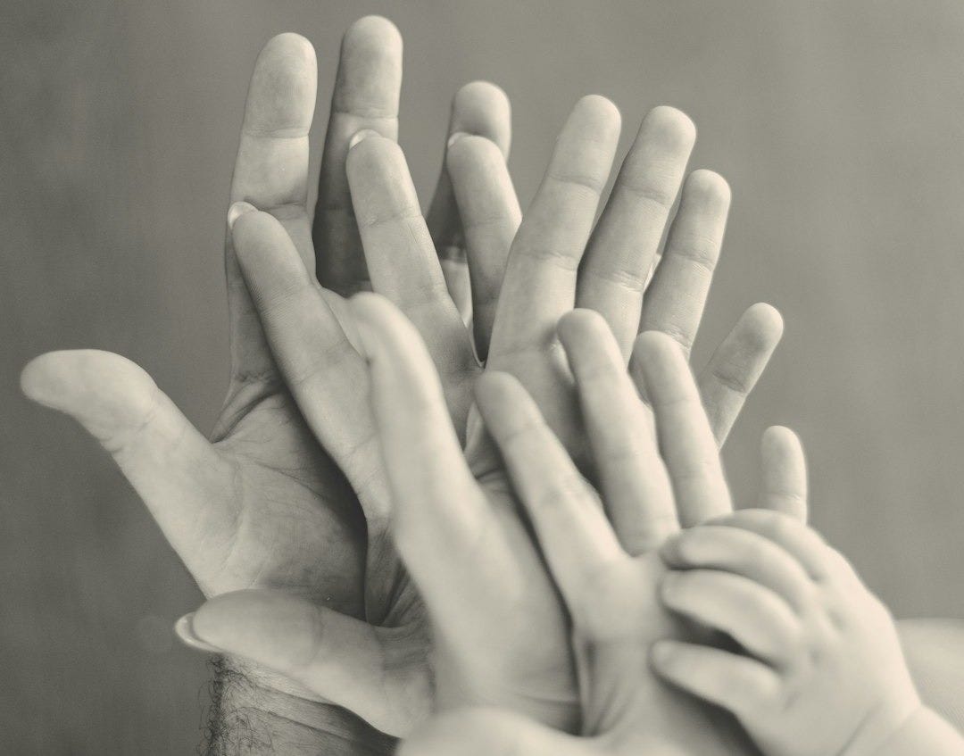 grayscale photo of family's hands grayscale photo of family's hands