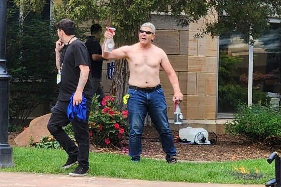 Photo of a shirtless man holding bottles and a spray bottle, appearing to be involved in a confrontation. Photo of a shirtless man holding bottles and a spray bottle, appearing to be involved in a confrontation.