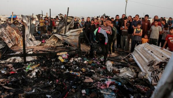 Palestinians look at the destruction after an Israeli strike where displaced people were staying in Rafah, Gaza Strip, Monday, May 27.