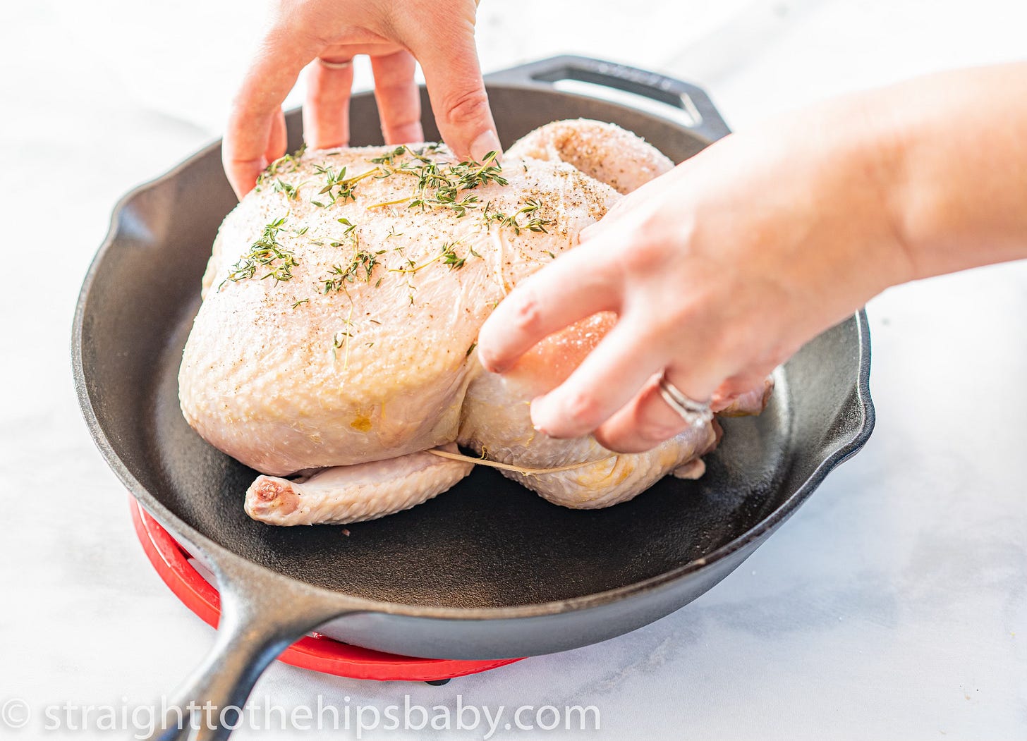 Raw whole chicken on a marble surface before roasting