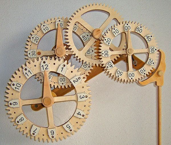 This may contain: two wooden clocks made to look like gears on a toothpick stick with numbers