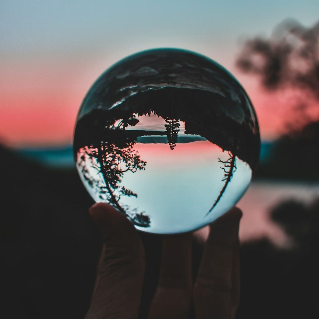 person holding clear crystal ball