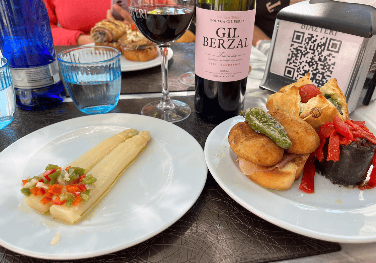 2 plates of pintxo appetizers with a glass of red wine in the background 2 plates of pintxo appetizers with a glass of red wine in the background