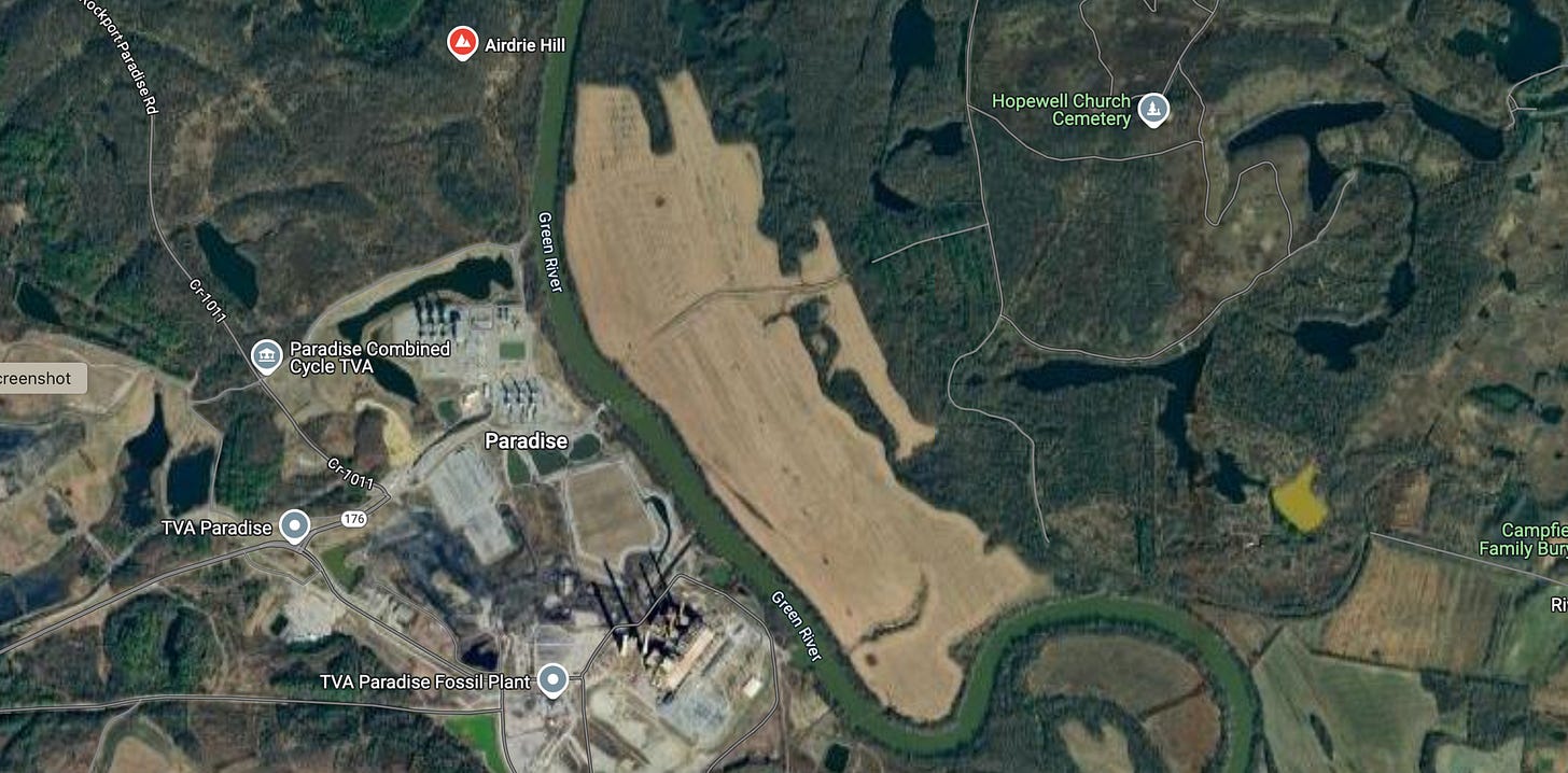 A river flows through farmland, forest, and an industrial coal facility A river flows through farmland, forest, and an industrial coal facility