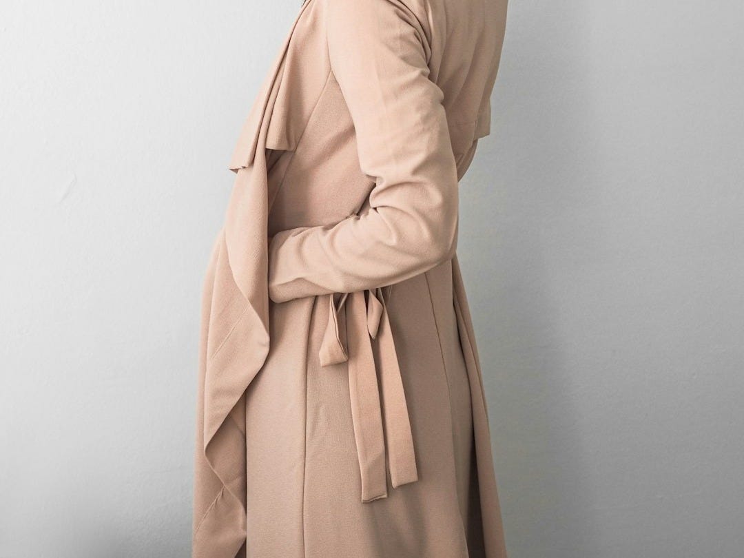 a woman in a trench coat and hat