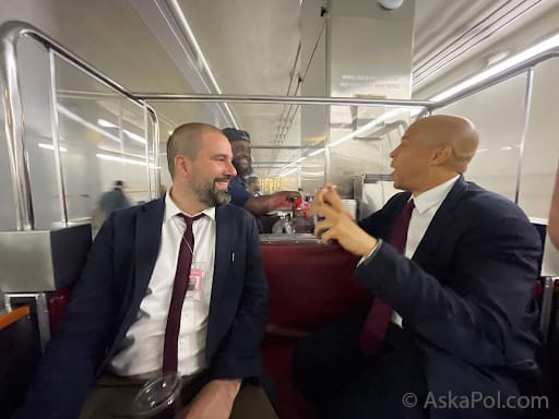 Two men in suits laugh while riding a tram and talking to conductor © Ask a Pol Two men in suits laugh while riding a tram and talking to conductor © Ask a Pol