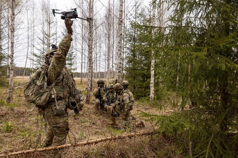 U.S. Army soldiers training with Titan V3 counter-unmanned aerial system technology in a wooded Latvian environment during the multinational Saber Strike 26 exercise.