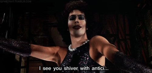 Dr. Frank N. Furter from Rocky Horror Picture show with a caption reading, "I see you shiver with antici..."