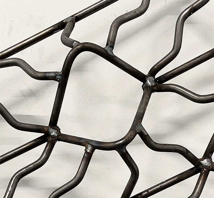 metal sculpture, pattern made of steel, diamond shape cut out in the steel pattern.