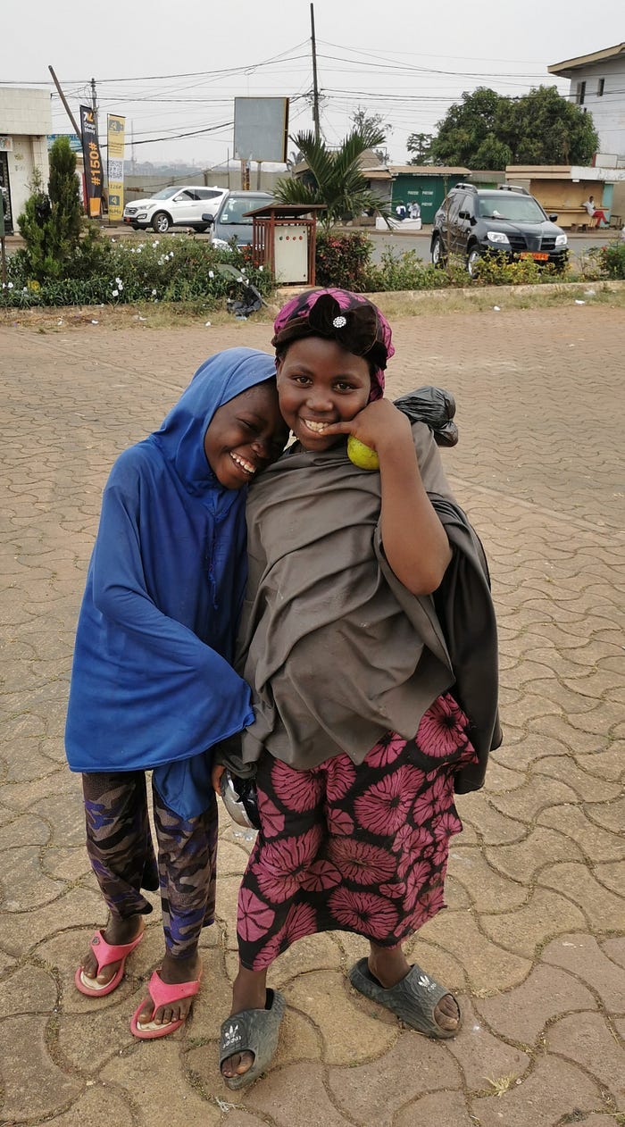 Two young girls in Islamic dress, smiling in a city square. Two young girls in Islamic dress, smiling in a city square.