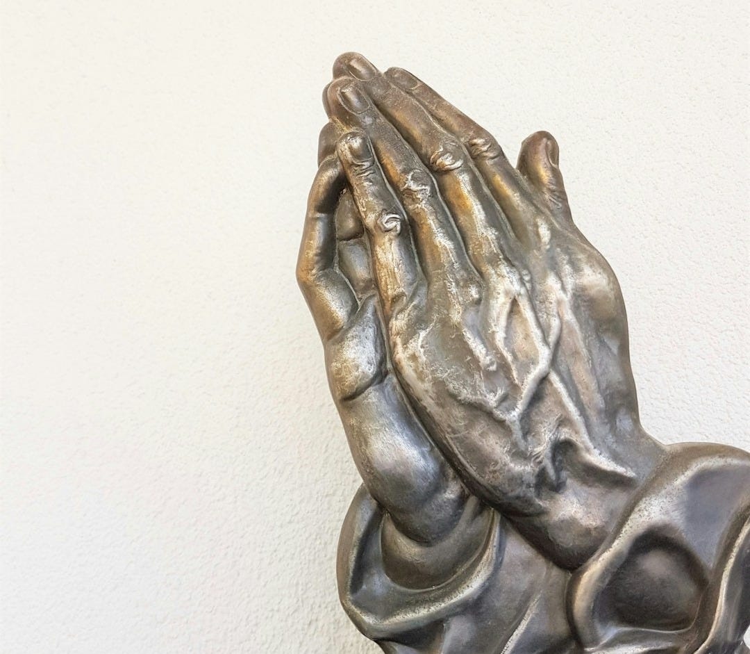 gray praying hand statue