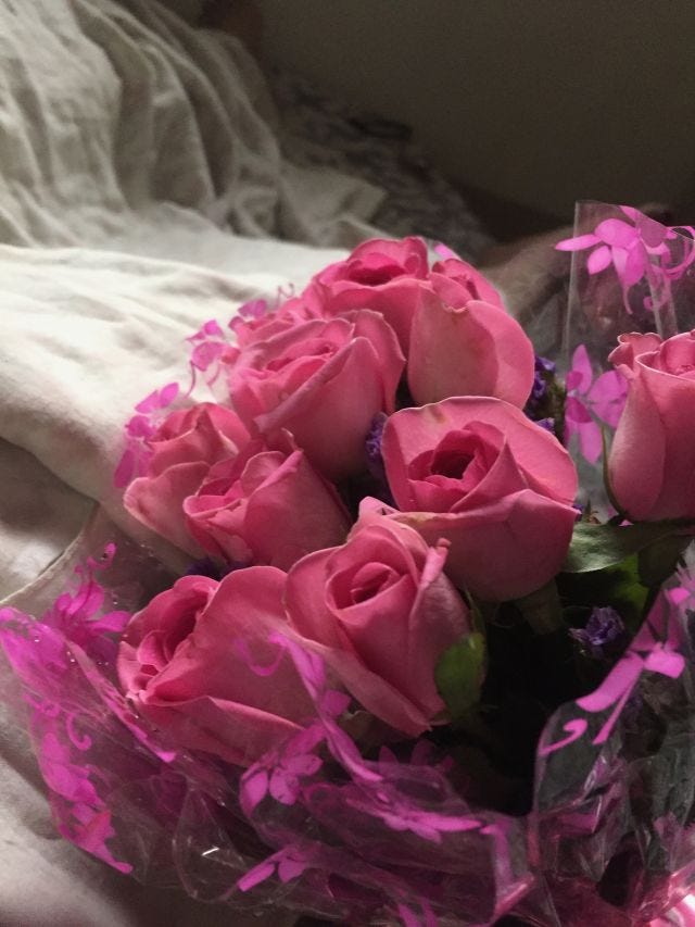 a boquet of pink roses wrapped in transparent foil.