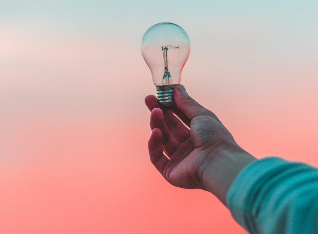 person holding light bulb person holding light bulb