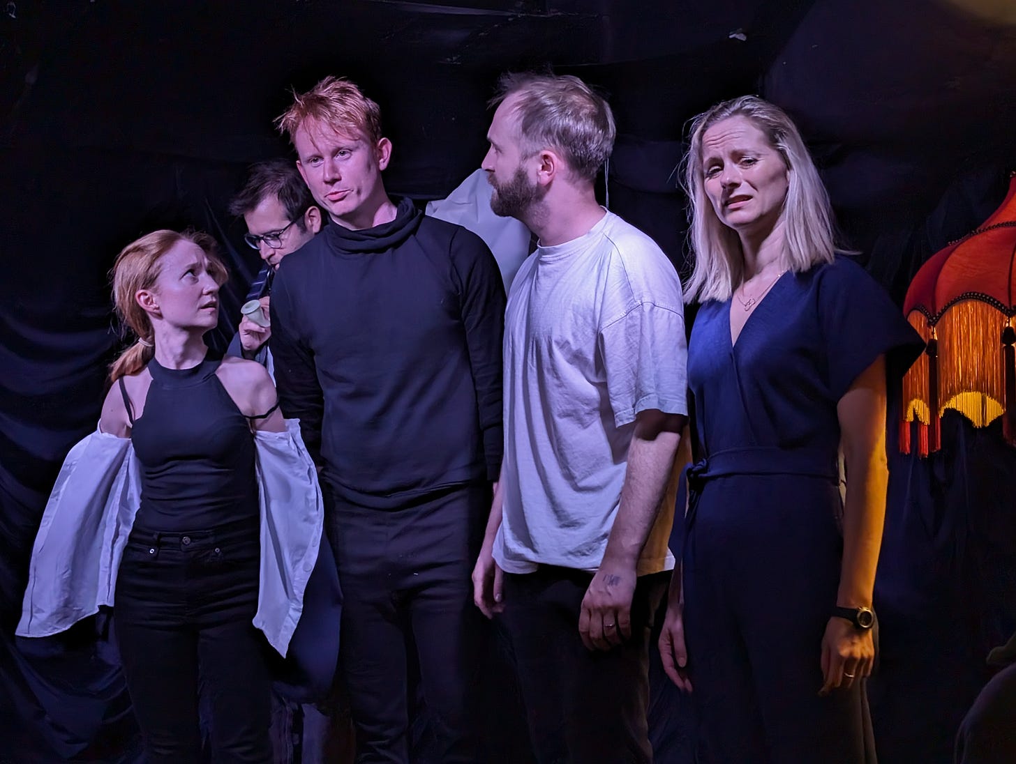Four comedians (a small woman with red hair, a man with red hair, a man with fair hair and a beard and a woman with blonde hair) stand on stage looking worried Four comedians (a small woman with red hair, a man with red hair, a man with fair hair and a beard and a woman with blonde hair) stand on stage looking worried