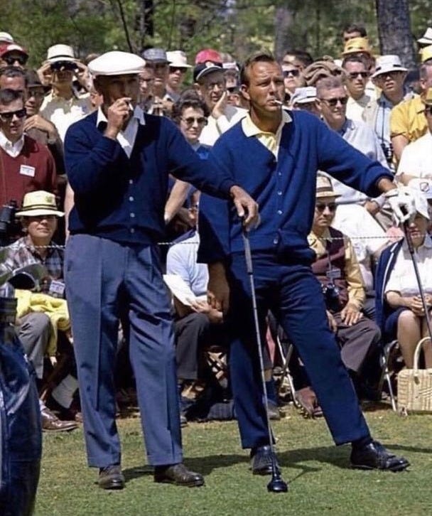 This may contain: two men are playing golf in front of an audience This may contain: two men are playing golf in front of an audience