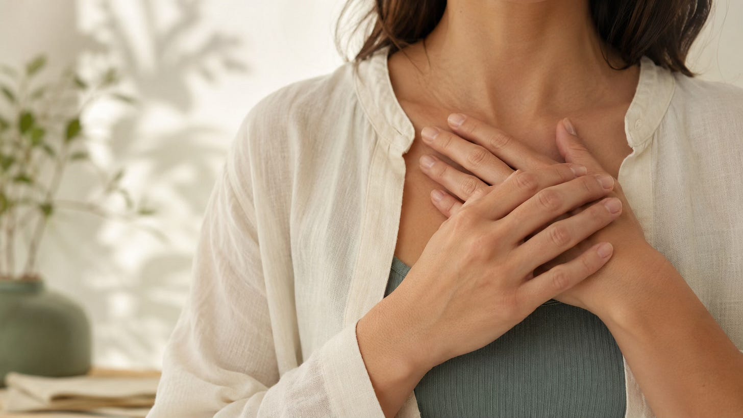 Hands resting gently near the chest, symbolizing nervous system support and emotional steadiness.