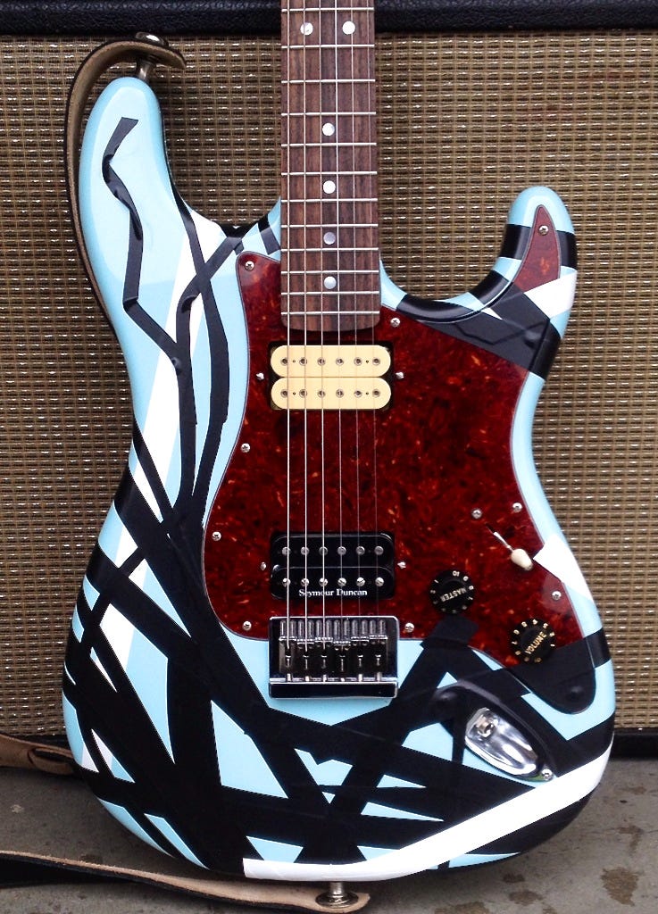  A guitar with a blue and black design, reminiscent of the one seen in the “Say It Ain’t So” video by Weezer in 1995.