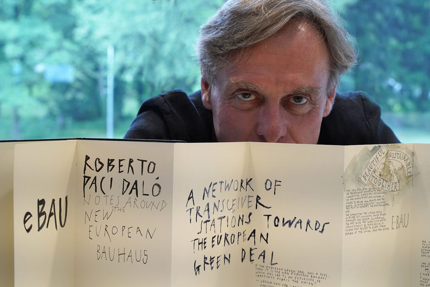 Portrait of Roberto Paci Dalò with the eBAU book opened in front of him Portrait of Roberto Paci Dalò with the eBAU book opened in front of him