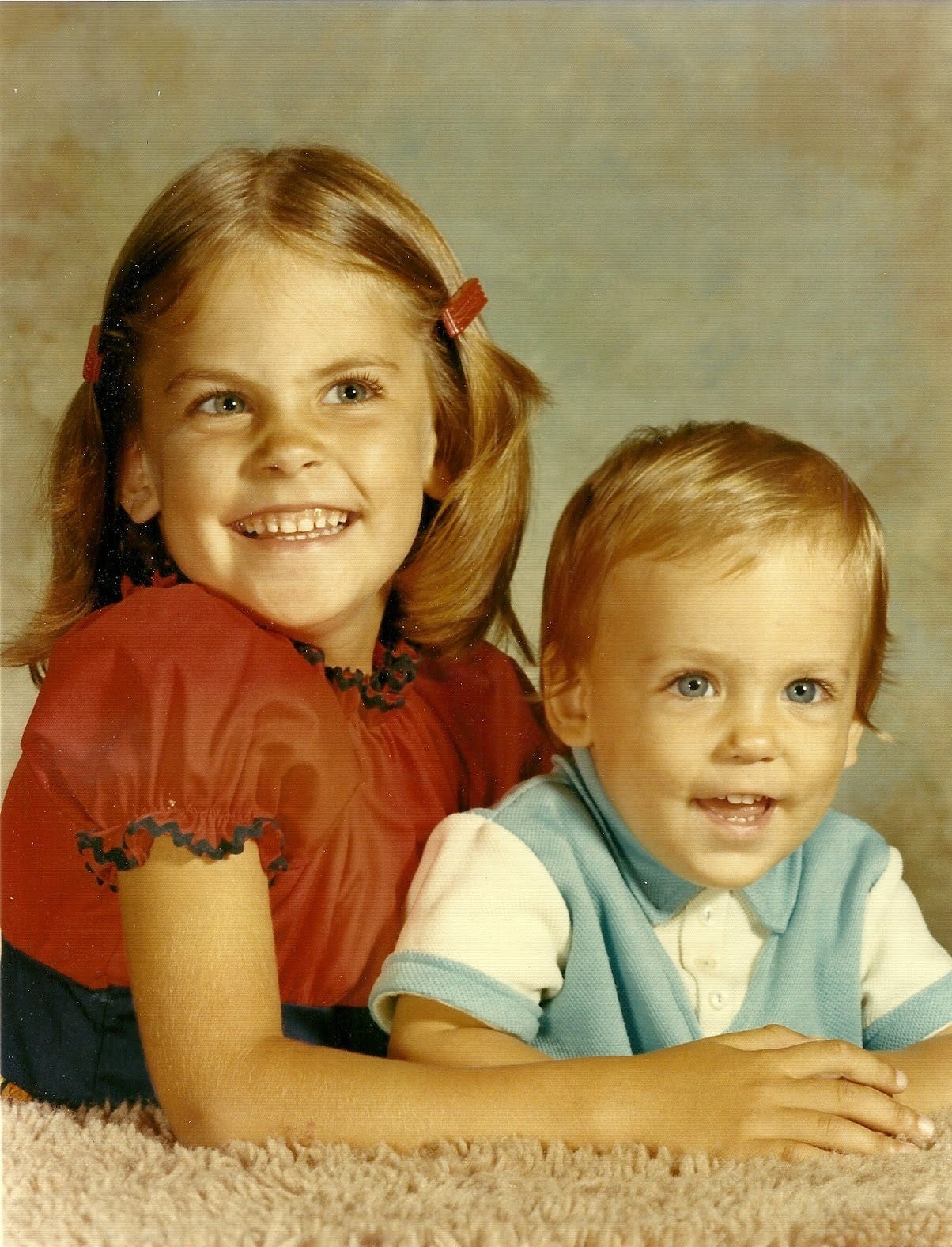 5-year-old girl poses with her 1-year-old brother for a photographer's portrait 5-year-old girl poses with her 1-year-old brother for a photographer's portrait