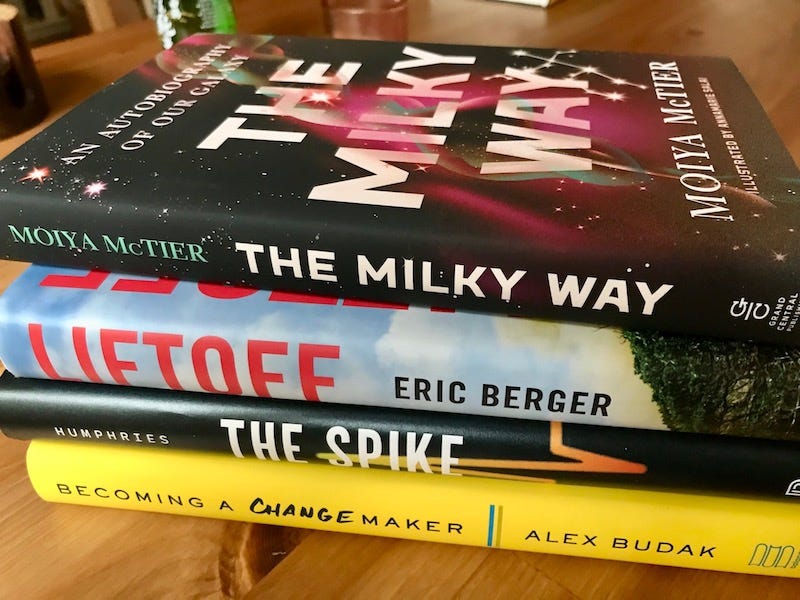 Photo of four books stacked on a table