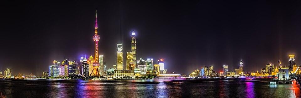 the skyline of Shanghai lit up in neon colors at night