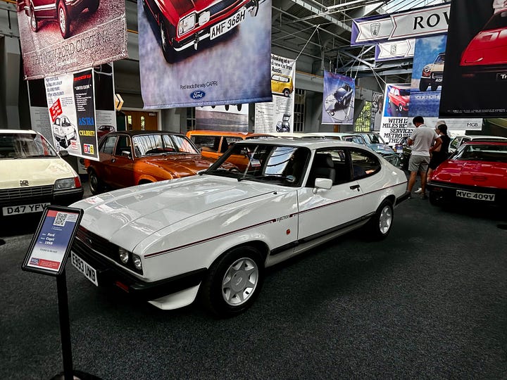 4 photos of cars at The Great British Car Journey A: 1972 Ford Escort B: 1972 Mk3 Ford Cortina C: 1973 Gilbern Invader - a car made in Wales and this is one of the last as the company went bankrupt in 1973 D: 1988 Ford Capri Images: Roland's Travels 2023
