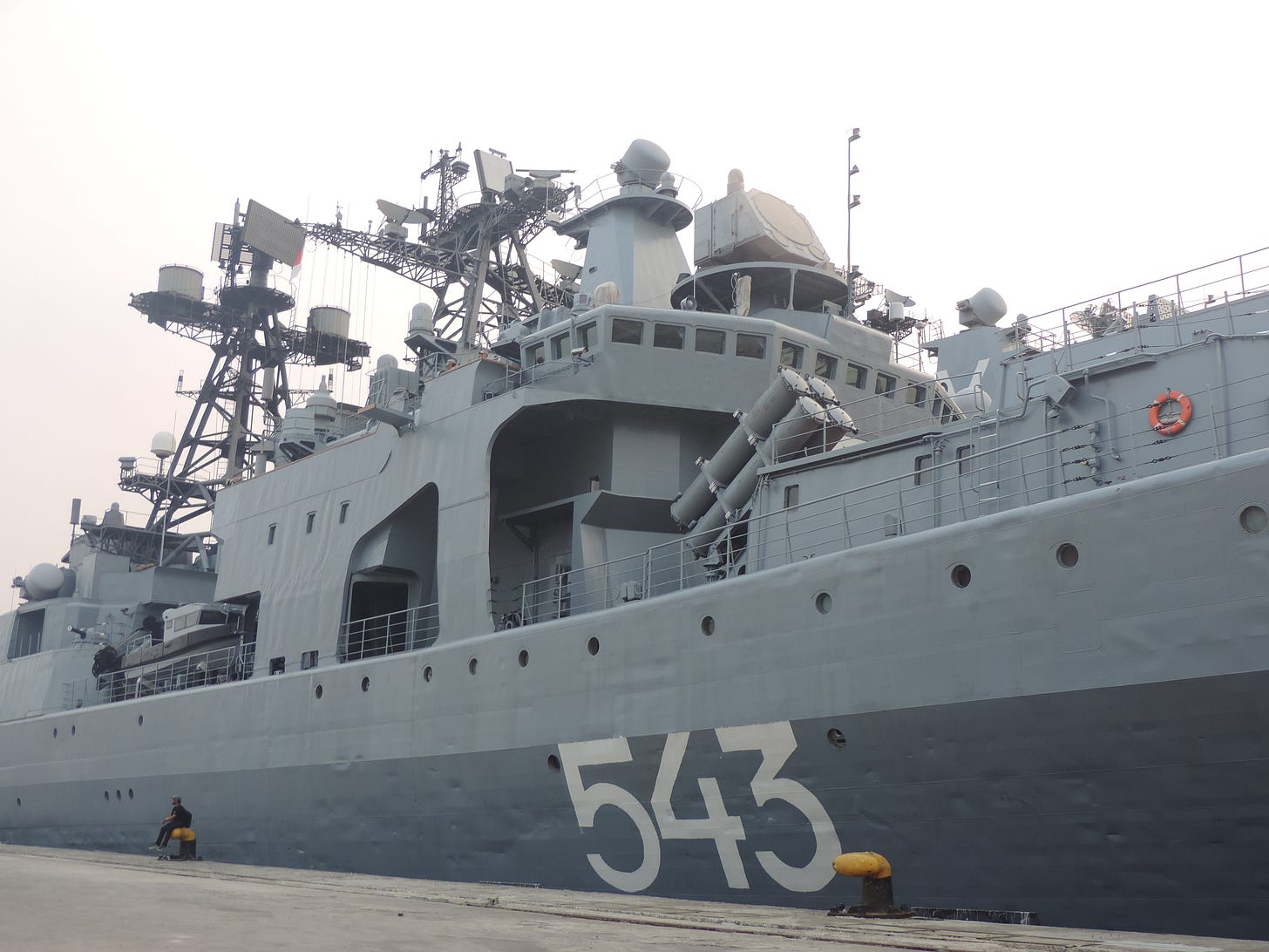 A low-angle view of the Russian Navy frigate Marshal Shaposhnikov bearing hull number 543 docked at Tanjung Priok Port in Jakarta during an Open Ship Day event. A low-angle view of the Russian Navy frigate Marshal Shaposhnikov bearing hull number 543 docked at Tanjung Priok Port in Jakarta during an Open Ship Day event.