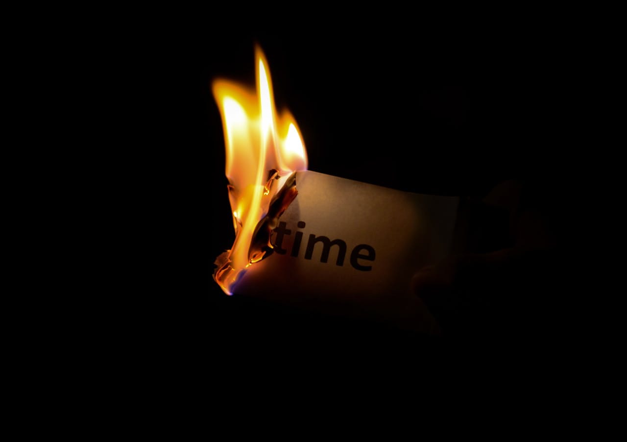 burning paper that says "time"