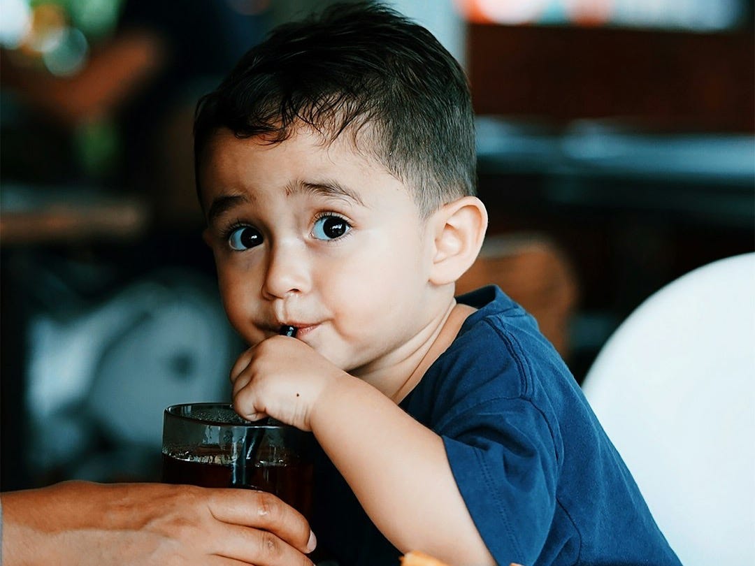 boy in blue crew neck t-shirt holding black camera