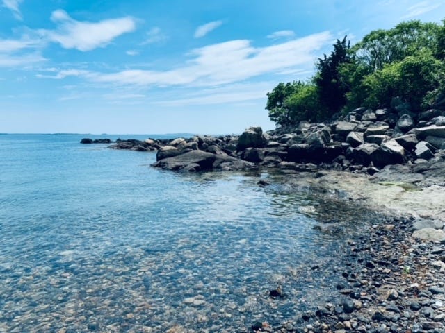 rocky new england coastline with a bright blue sky