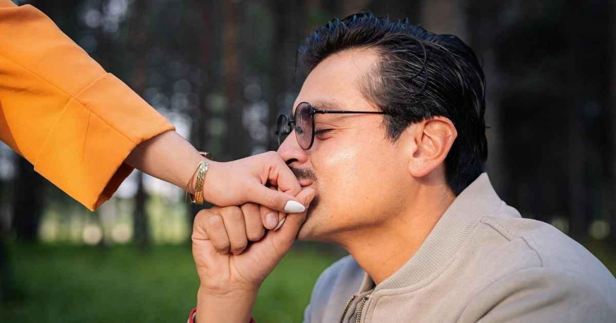 Man Kissing Woman's Hand Outdoors