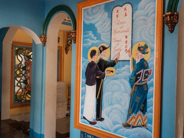 A painting on a wall of religious figures standing in apparent clouds in front of a tablet.