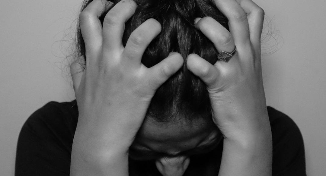 a woman covering her face with her hands a woman covering her face with her hands