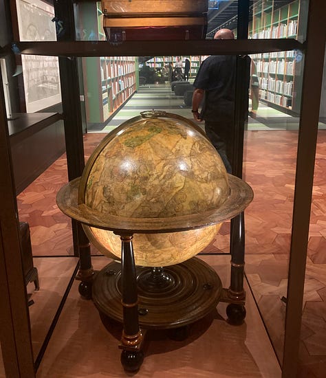 A series of nine photos inside the new library at MONA art museum shows shelves of books, reading lounges, cheeky covers, artist books, globes and more.