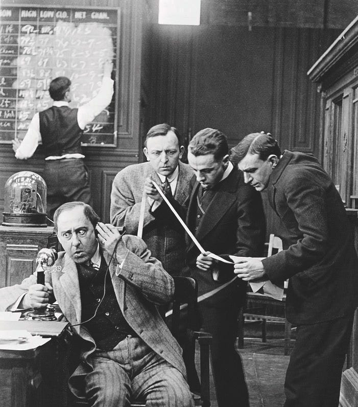 Men Reading Stock Ticker Tape by Bettmann