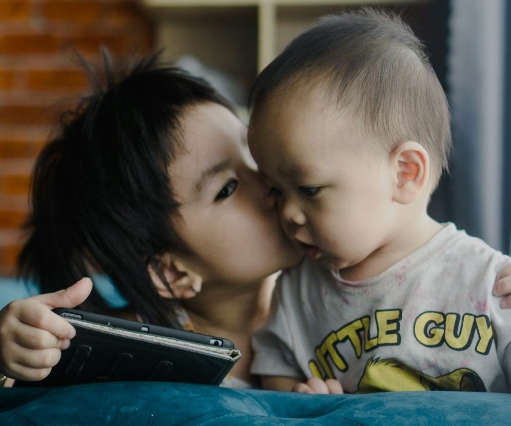 a woman kissing a small child on the cheek