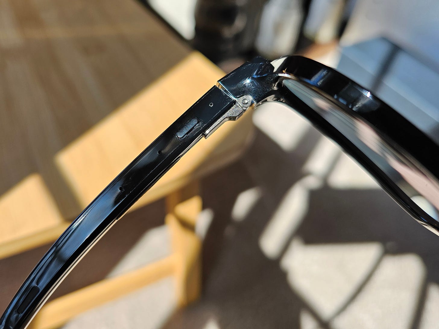 Close-up of the power button and hinge on the Nuance Audio Hearing Glasses.