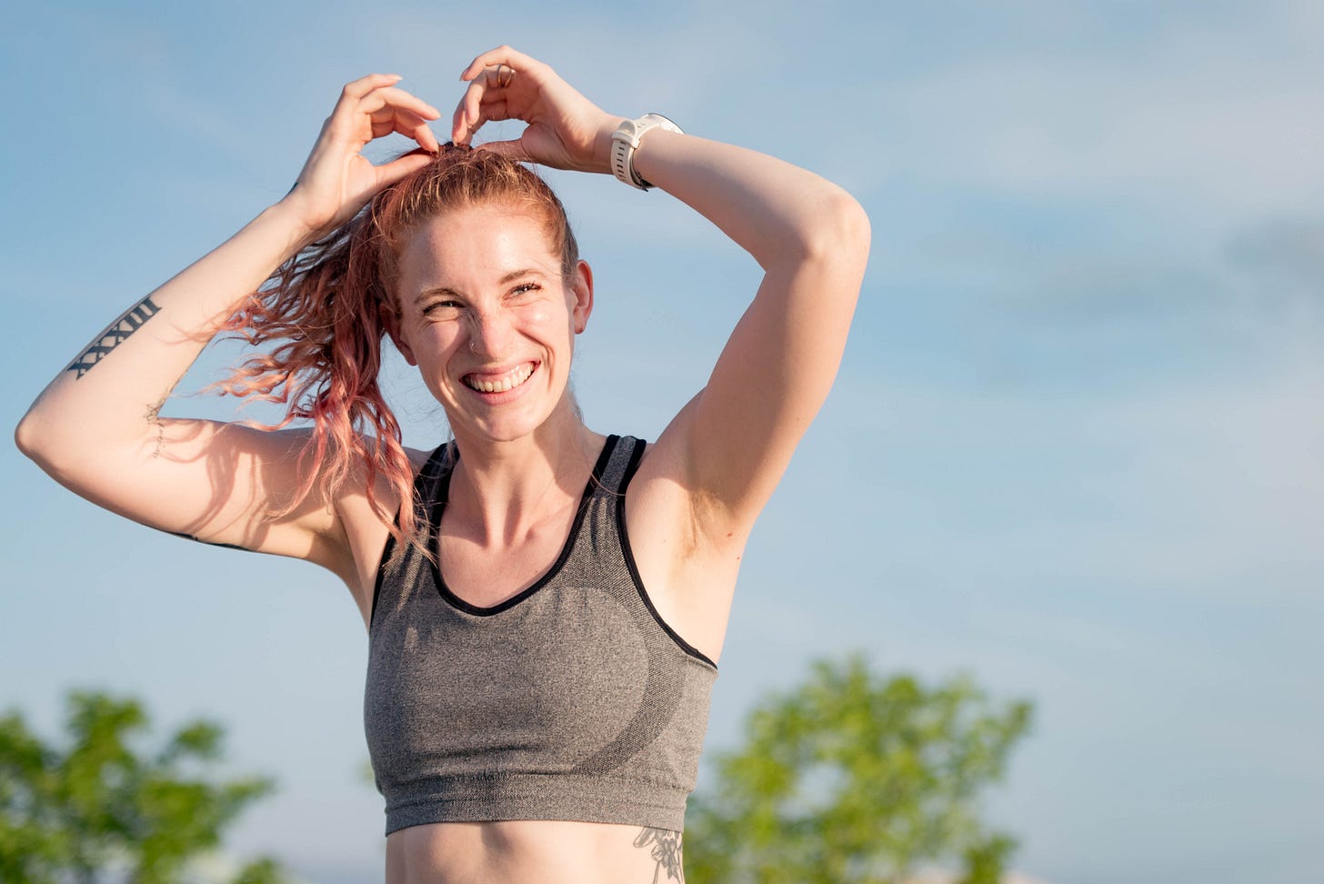 Sustainable lifestyle influencer Emmery Brakke smiles while fixing her hair before a run