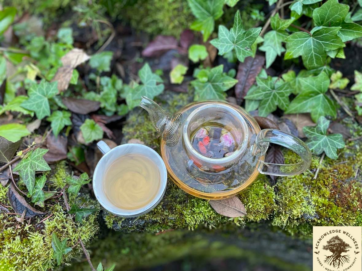 photo of our Stress Ease Tea Blend in a tea pot on the ledge covered by ivy.