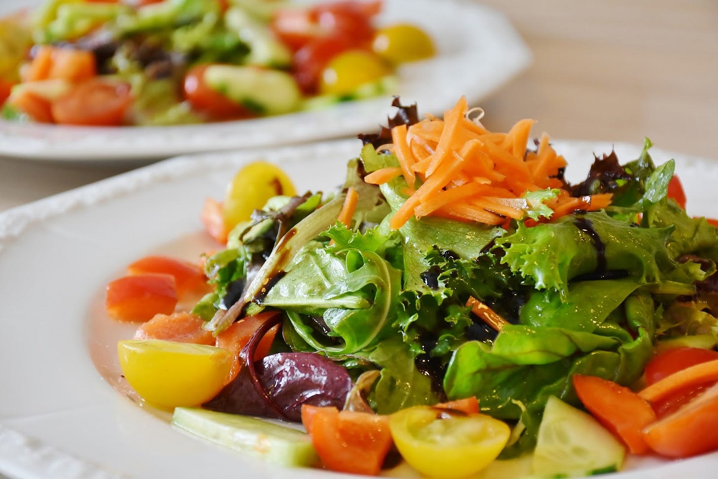 Plates of salad, with grated carrot, tomatoes, leafy greens. Looks healthy to me!