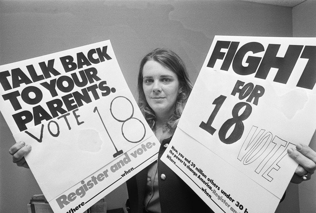 Woman holding signs that say Talk Back to Your Parents. Vote 18 and Fight for 18 Woman holding signs that say Talk Back to Your Parents. Vote 18 and Fight for 18